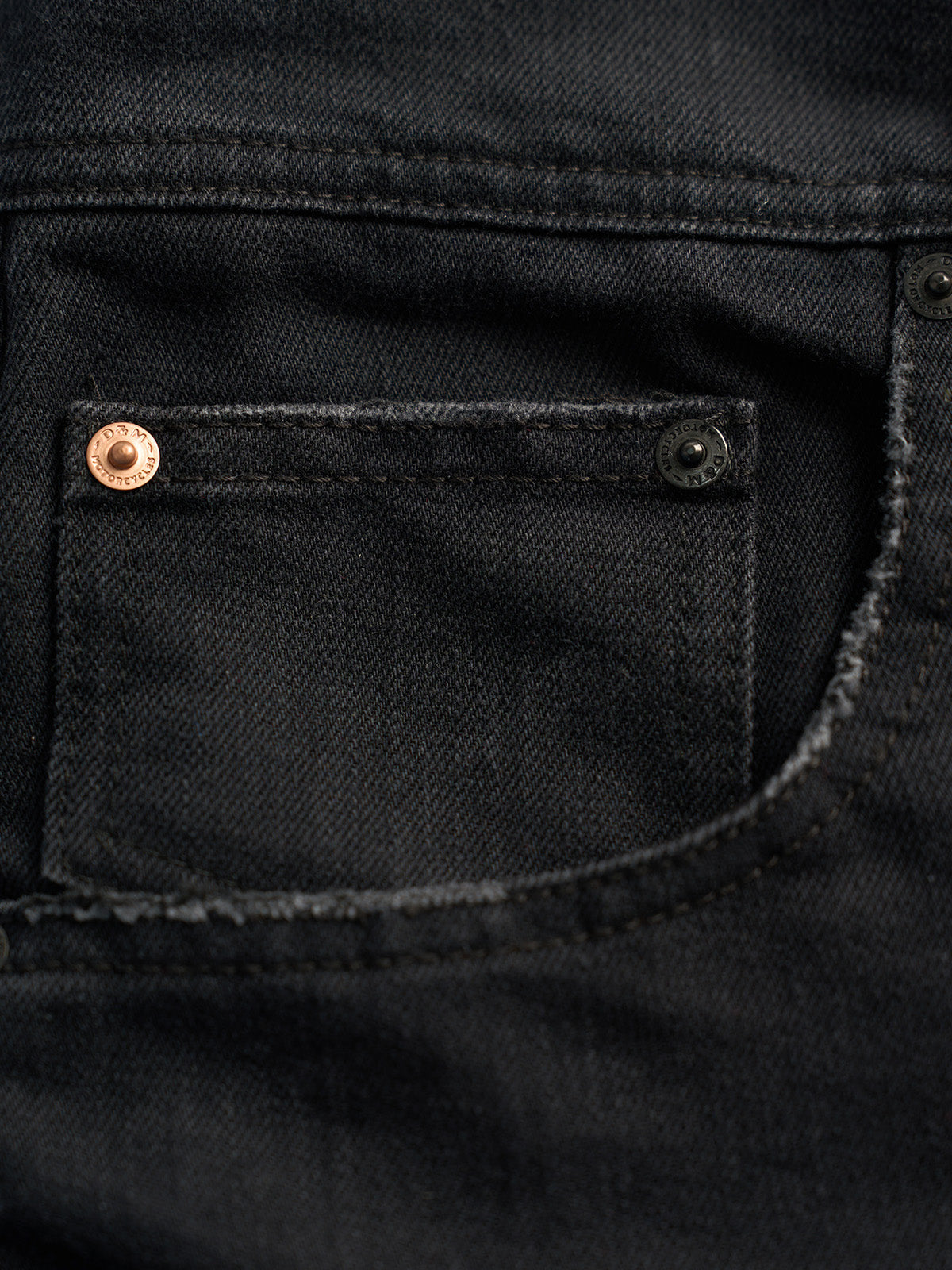 Modelo con Short de Mezclilla Alex en Negro, con una playera de bolsillo — Demons & Machines. #color_negro
