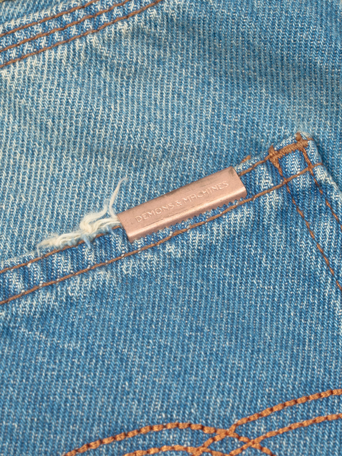 Jeans Alex Oversize Fit, detalle — desgastes reparados a mano y pespunte de triple aguja. #color_azul_claro
