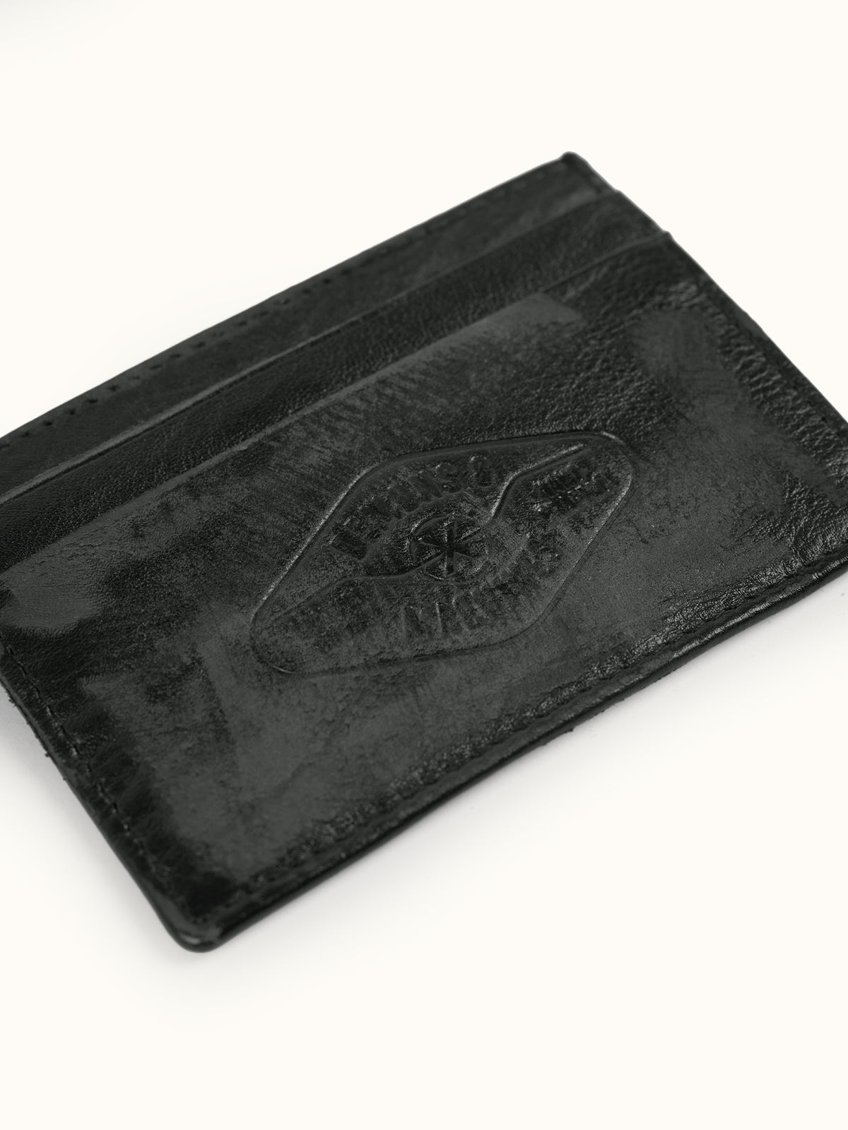 Tarjetero de Piel Atlanta en Negro, vista trasera — el logo grabado en el reverso. #color_negro