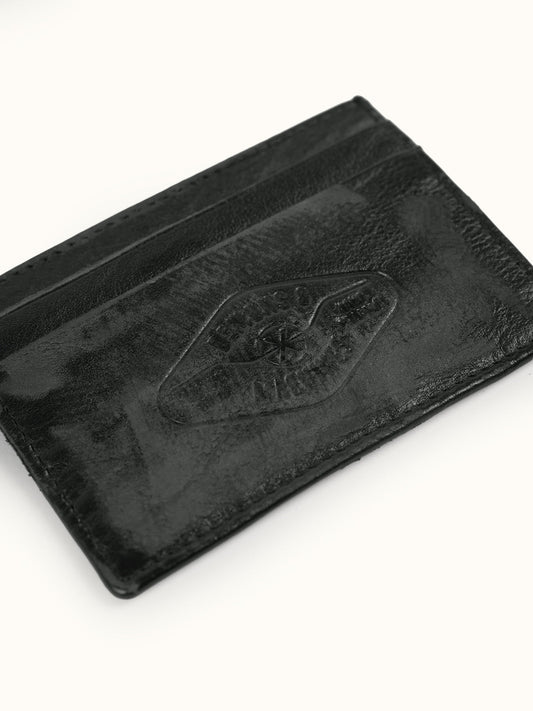 Tarjetero de Piel Atlanta en Negro, vista trasera — el logo grabado en el reverso. #color_negro