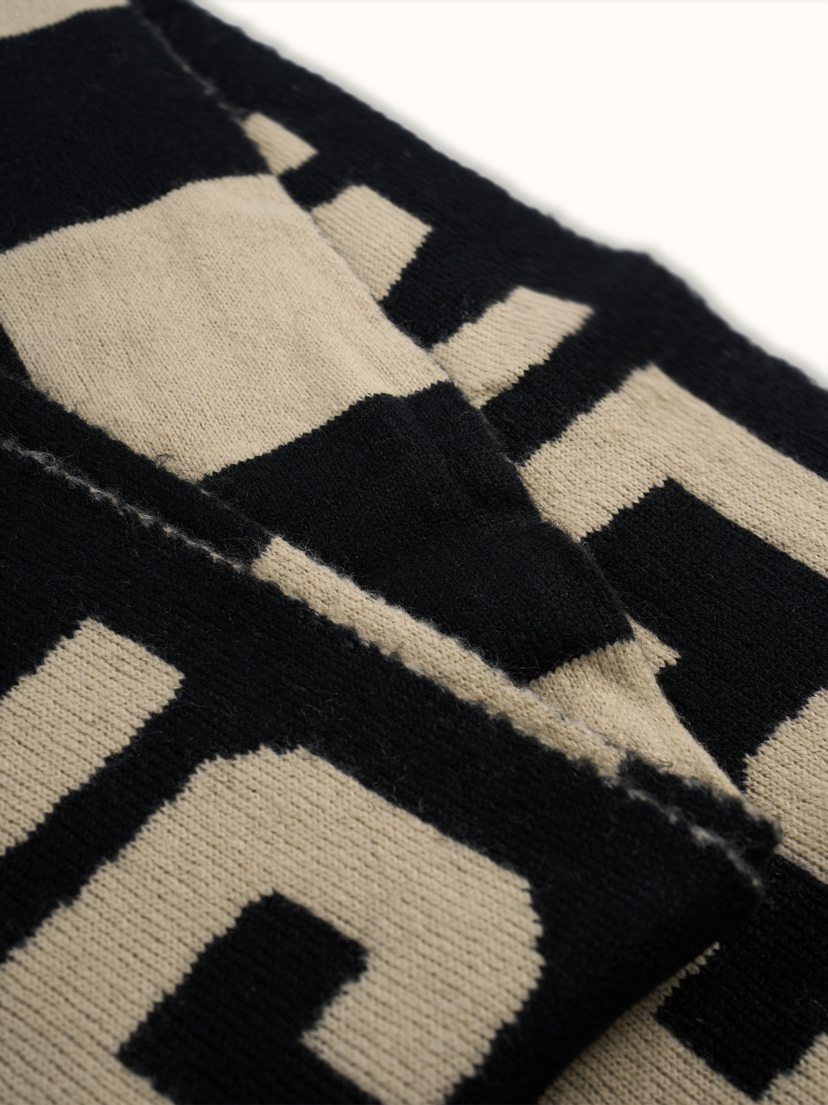 Bufanda Oversize Lenny, detalle — un diseño jacquard bitono a lo largo de toda la pieza. #color_negro