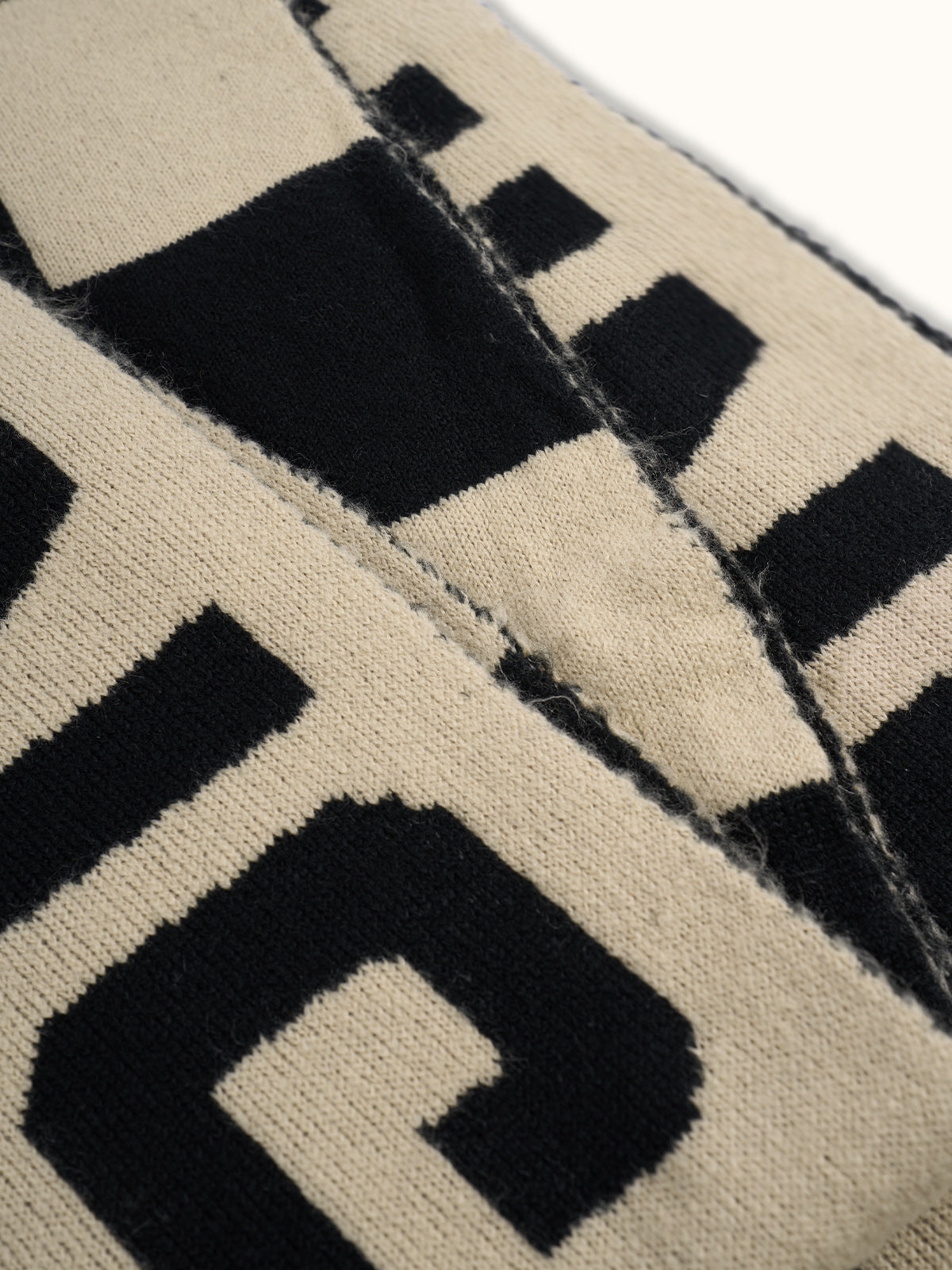 Bufanda Oversize Lenny, detalle — un diseño jacquard bitono a lo largo de toda la pieza. #color_marfil