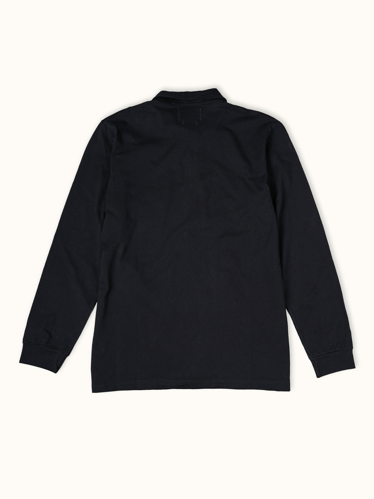 Playera Polo Manga Larga en Negro, vista trasera — la espalda limpia de corte regular. #color_negro