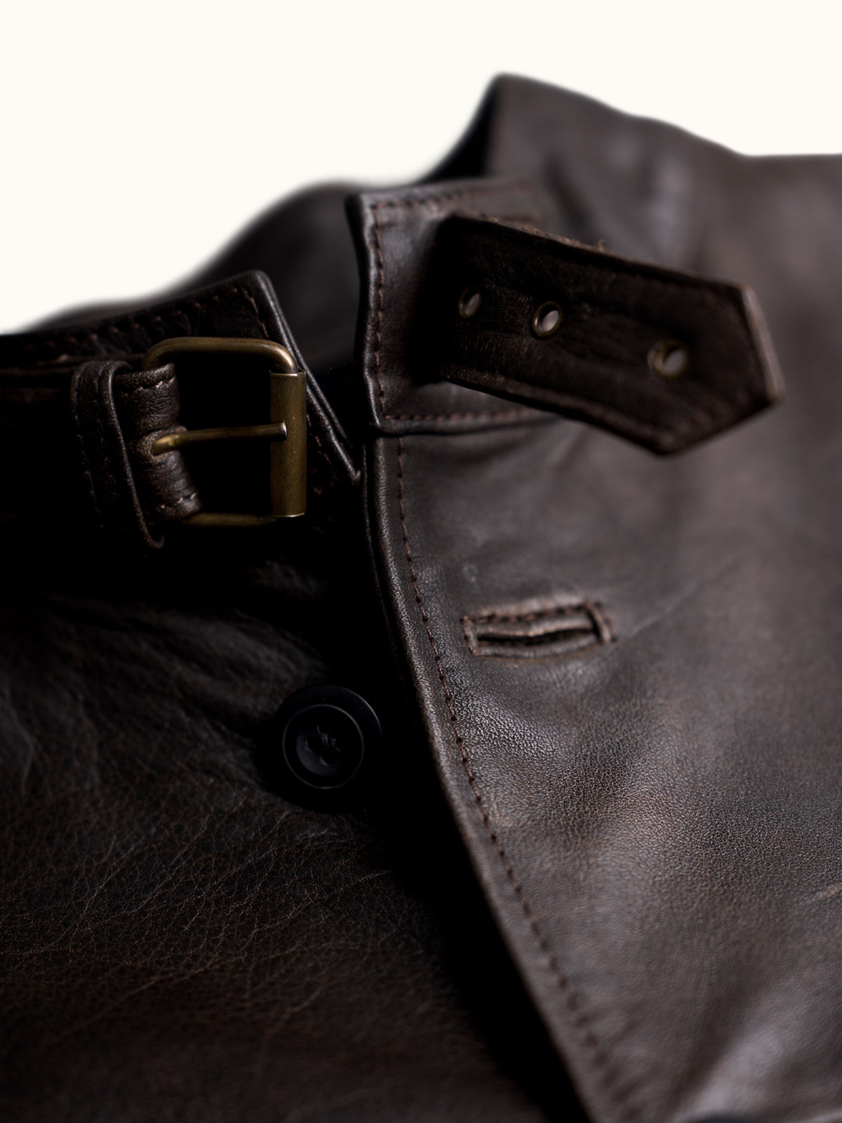 Chamarra de Piel Michigan, detalle — cuello alto con correa ajustable de hebilla metálica y bolsas de parche. #color_café