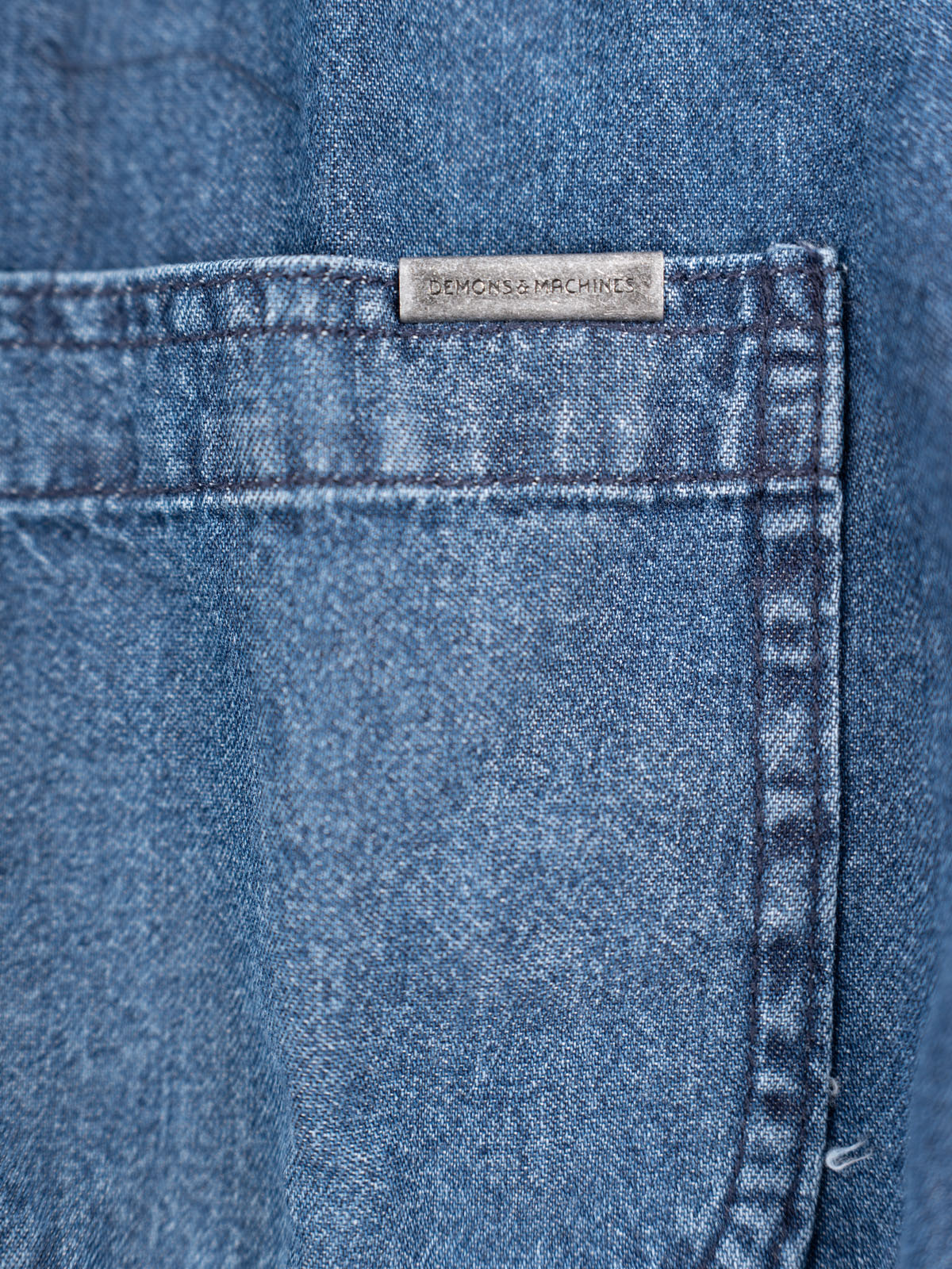 Camisa de Mezclilla Morris, detalle — bolsas de parche en el pecho y botones de resina negro mate ojo. #color_azul_medio