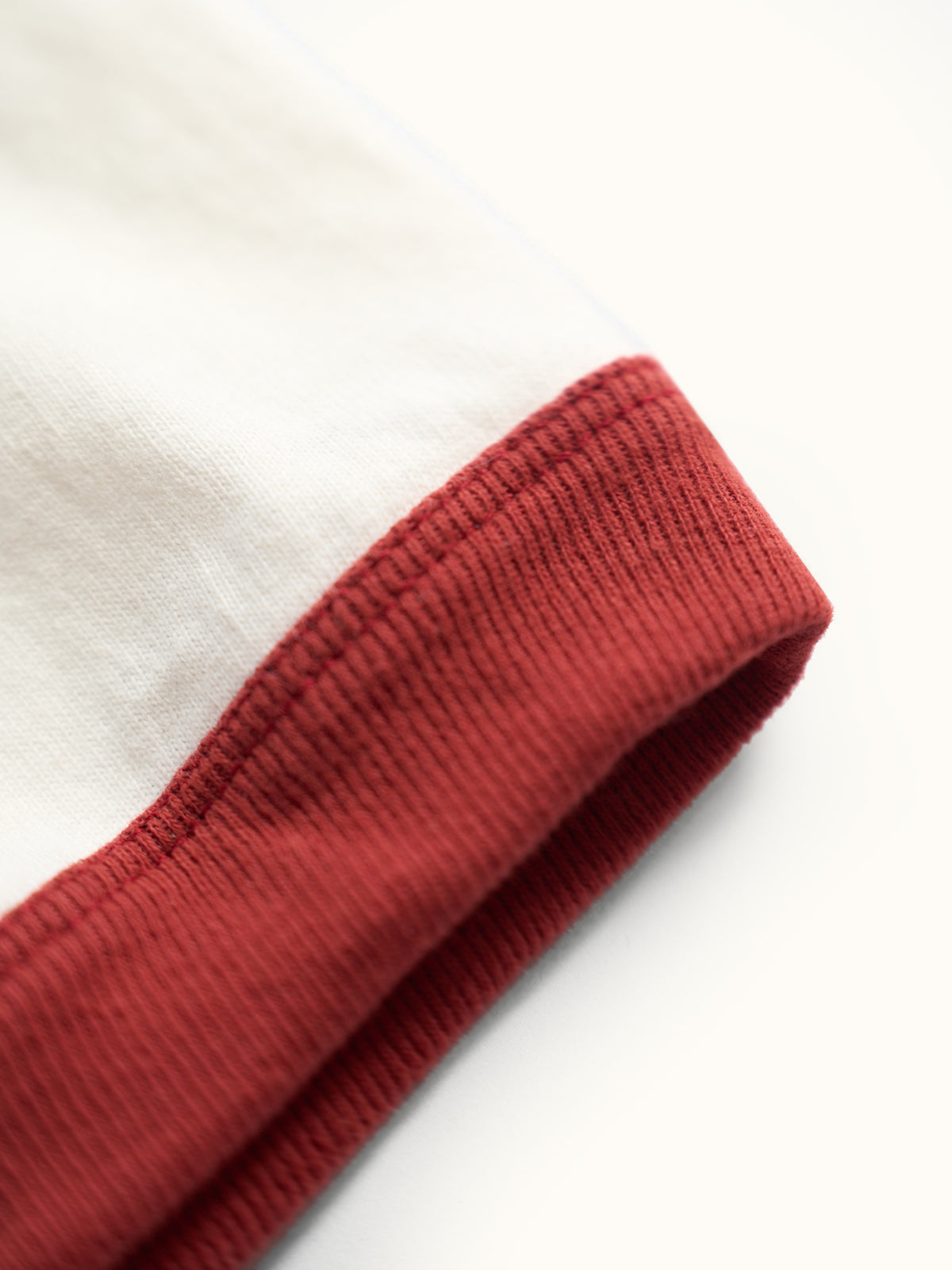 Playera slim de algodón premium con cuello redondo y puños a contraste estilo ringer, confeccionada en Argentina. #color_ladrillo