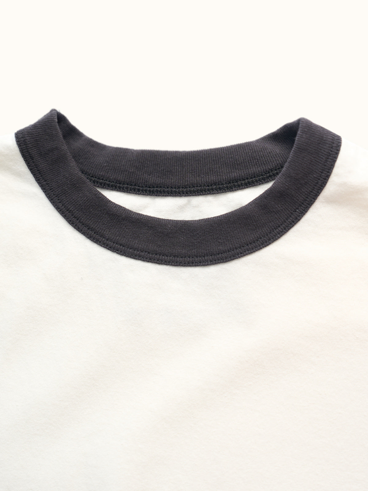 Playera slim de algodón premium con cuello redondo y puños a contraste estilo ringer, confeccionada en Argentina. #color_negro