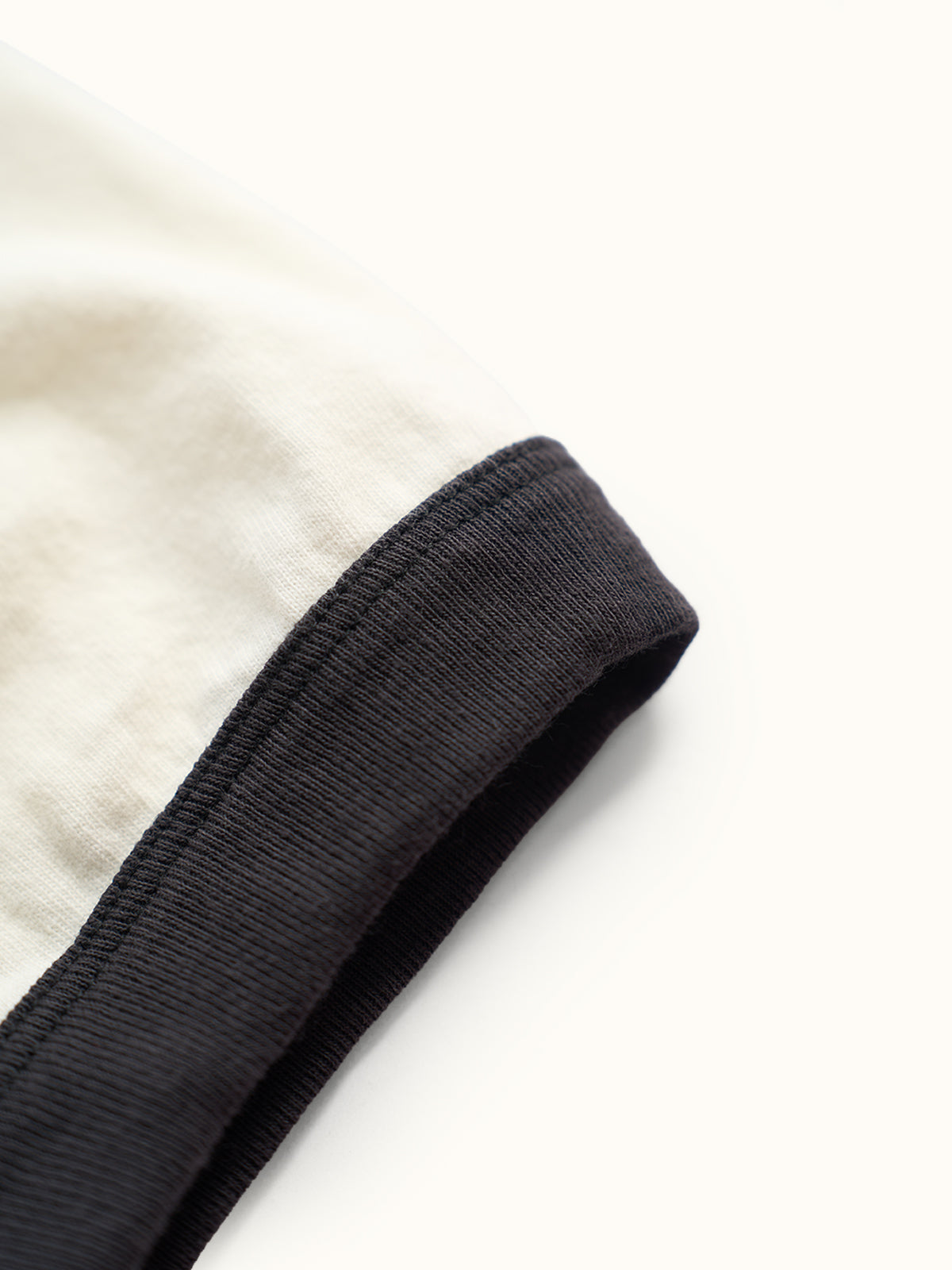 Playera slim de algodón premium con cuello redondo y puños a contraste estilo ringer, confeccionada en Argentina. #color_negro