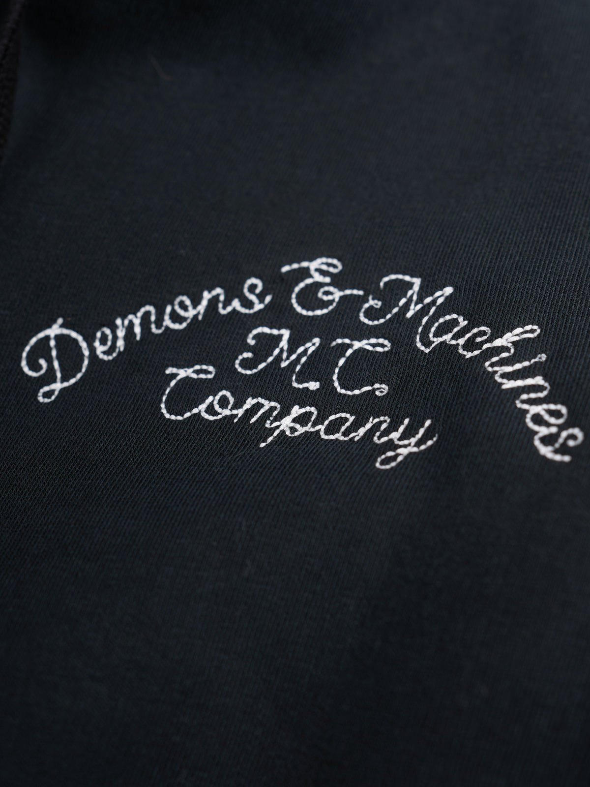 Modelo con Sudadera con Cierre Prescott Bordada en Negro, cerrada sobre una playera — Demons & Machines. #color_negro