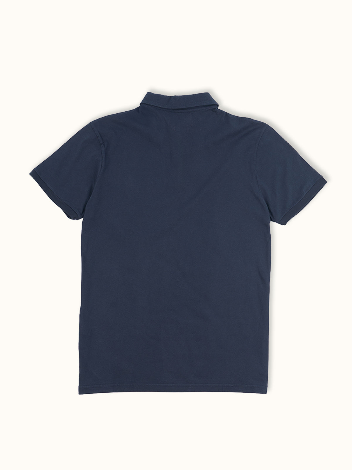 Playera Polo Manga Corta en Azul Marino, vista trasera — la espalda limpia de corte regular. #color_azul_marino