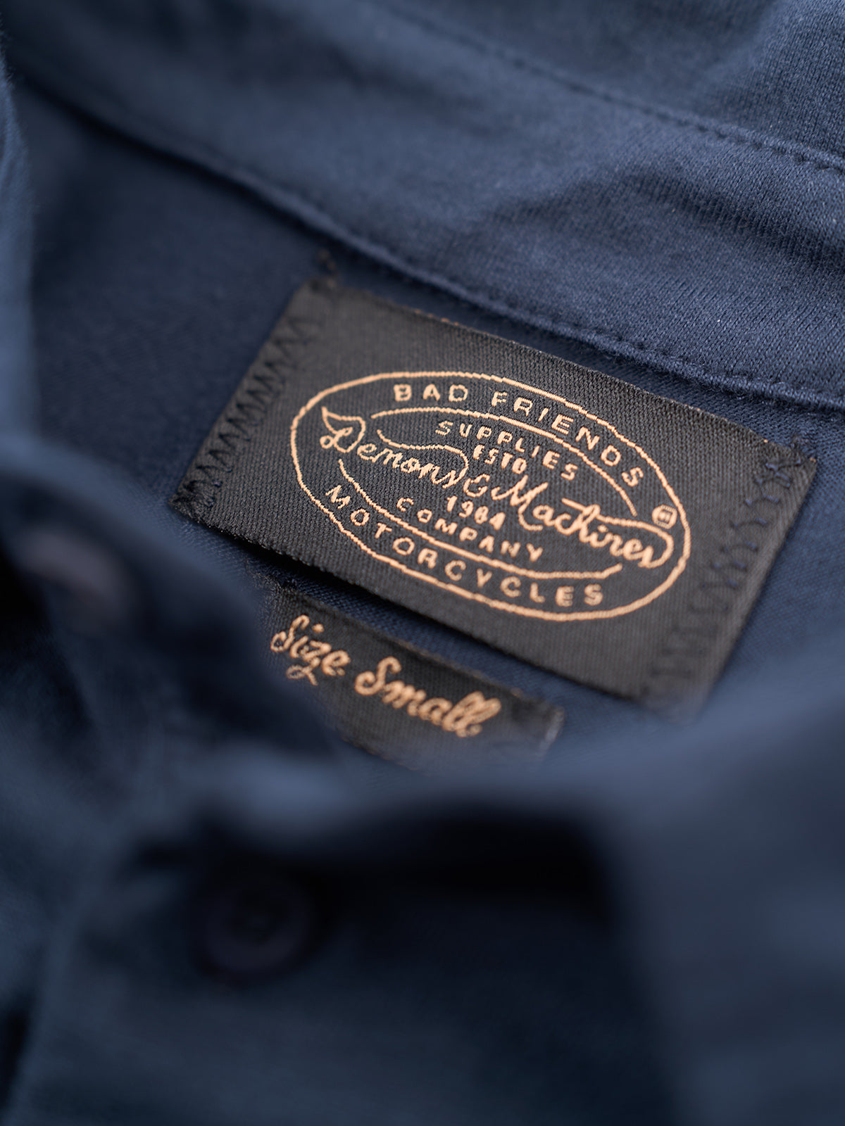 Playera Polo Manga Corta, detalle — logo bordado al tono en el pecho, botones a juego y puños tejidos. #color_azul_marino